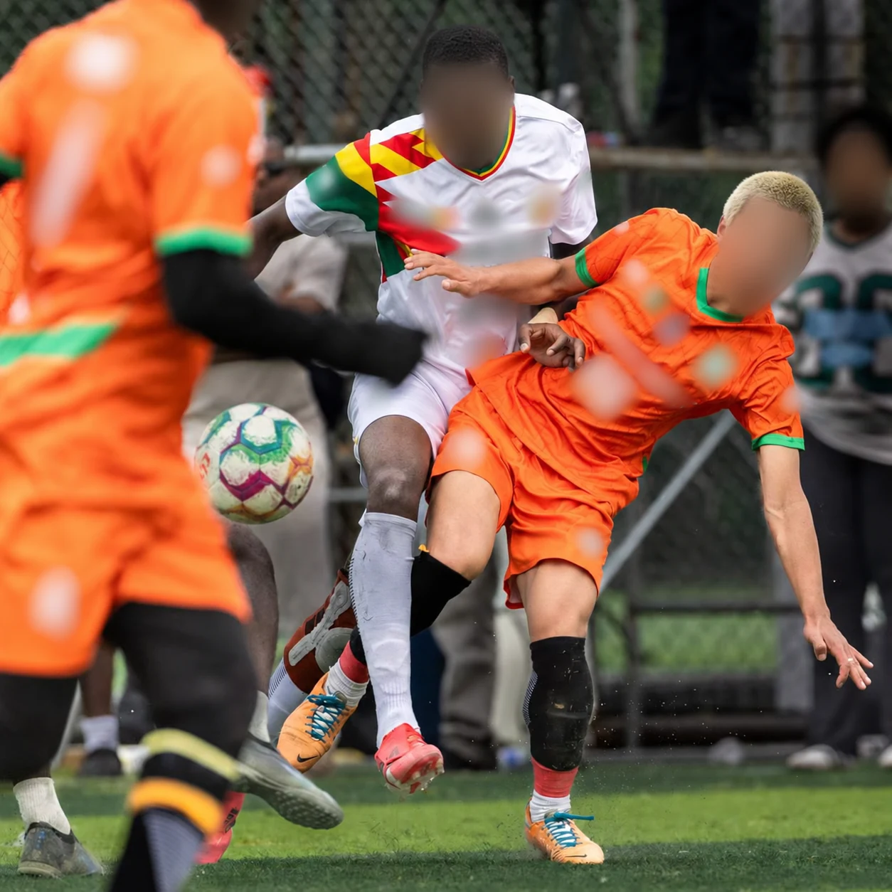 Privacy-edited football project image showing contrasting shirts and shorts in an outdoor match.