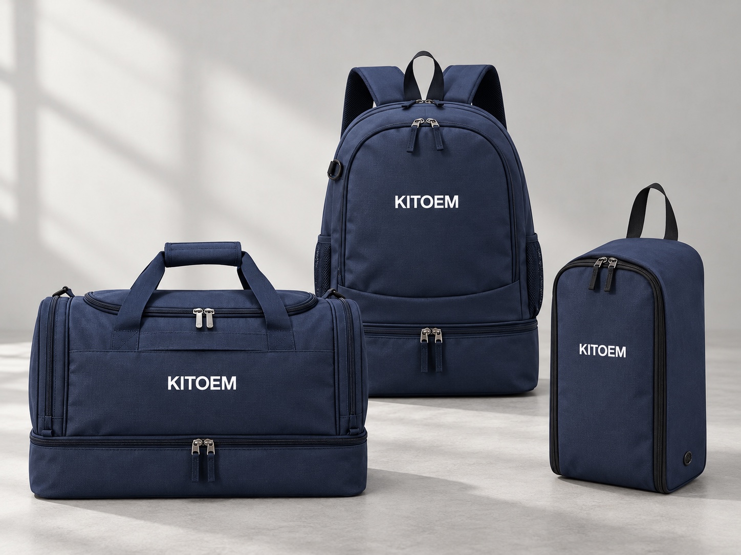 Navy KITOEM backpack, kit duffle and boot bag arranged as a coordinated football travel set